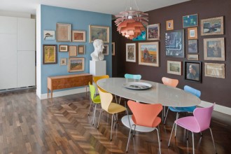 Dietro la parete grigio azzurra della zona pranzo si nasconde la cucina. Il tavolo Tulip di Eero Saarinen per Knoll è circondato dalle sedie di Fritz Hansen laccate in vari colori (design Arne Jacobsen). Al centro