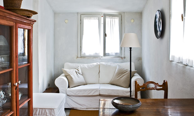 Il divano bianco e la credenza a vetri arredano l’ingresso-soggiorno- pranzo in uno stile tra classico e rustico; di provenienza Umbra le sedie. Collegata al soggiorno la cucina.