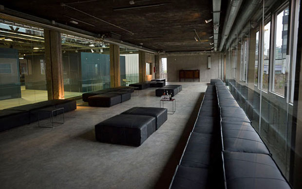 Gli spazi di Progetto Calabiana Milano. Il divano nero è stato realizzato su disegno di Massimiliano Bizzi e il team di M.Seventy