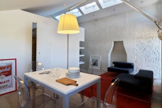 Il recupero del sottotetto e l'eliminazione delle divisioni tra gli spazi ha permesso di aumentare la luminosità dell'appartamento